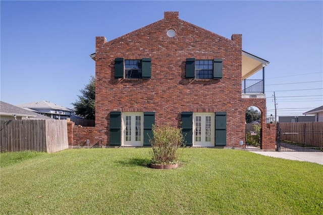 view of front of house featuring a balcony, a front lawn, and french doors