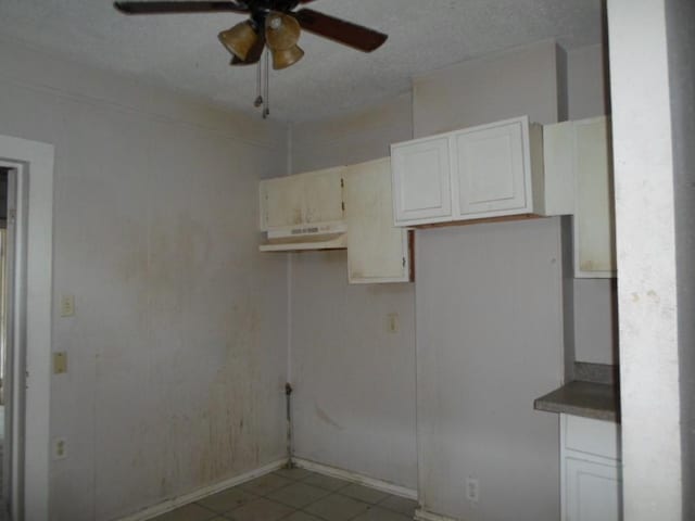 kitchen with white cabinetry, ceiling fan, and a textured ceiling