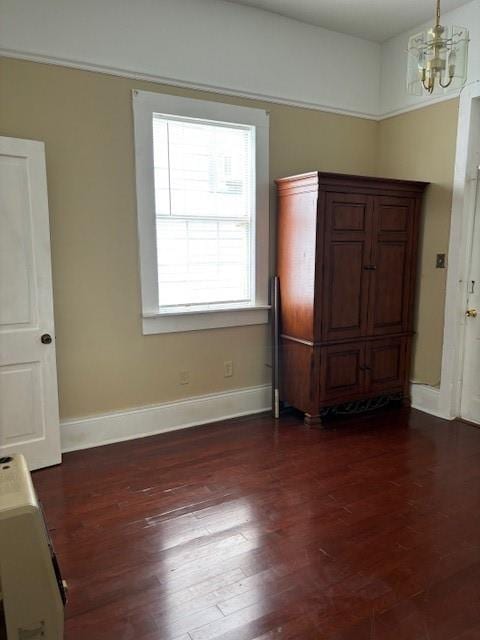 unfurnished dining area with hardwood / wood-style floors and an inviting chandelier