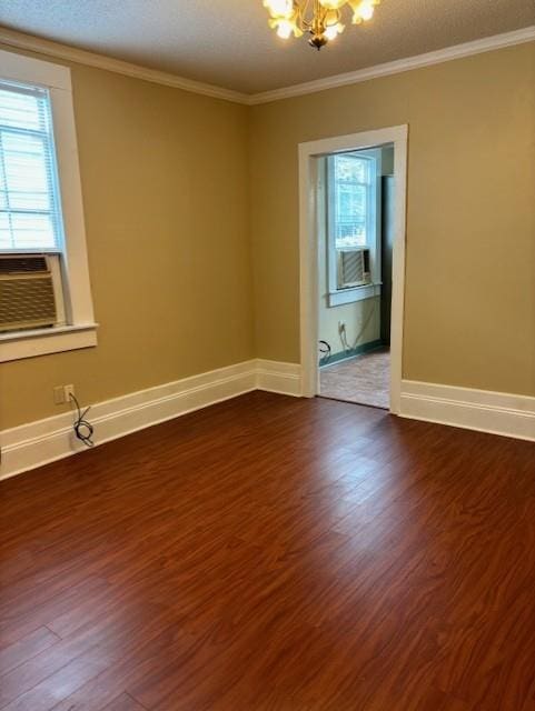 unfurnished room with dark hardwood / wood-style floors, cooling unit, ornamental molding, a chandelier, and a textured ceiling