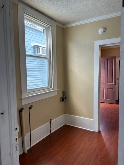 unfurnished room featuring a textured ceiling, dark hardwood / wood-style flooring, cooling unit, ornamental molding, and a chandelier