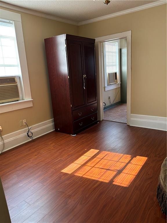 spare room featuring ornamental molding, cooling unit, hardwood / wood-style floors, and a textured ceiling