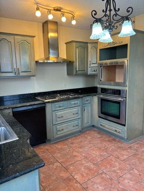 kitchen with wall chimney exhaust hood, a textured ceiling, appliances with stainless steel finishes, and pendant lighting