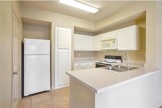 kitchen with light tile patterned floors, sink, kitchen peninsula, white appliances, and white cabinetry