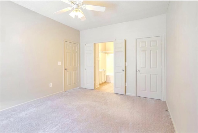 unfurnished bedroom with light carpet, ceiling fan, and ensuite bathroom