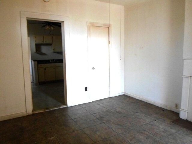 tiled spare room featuring ceiling fan