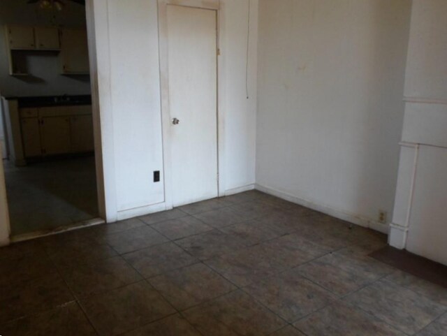 unfurnished bedroom with dark tile patterned floors and a closet