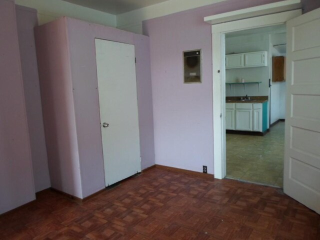 unfurnished bedroom featuring dark parquet floors and sink