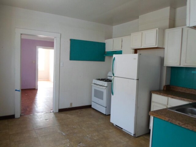 kitchen with white appliances, sink, and white cabinets