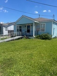 rear view of property with a porch and a lawn