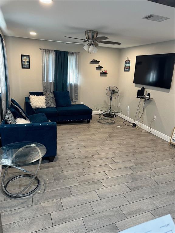 living room with light wood-type flooring and ceiling fan