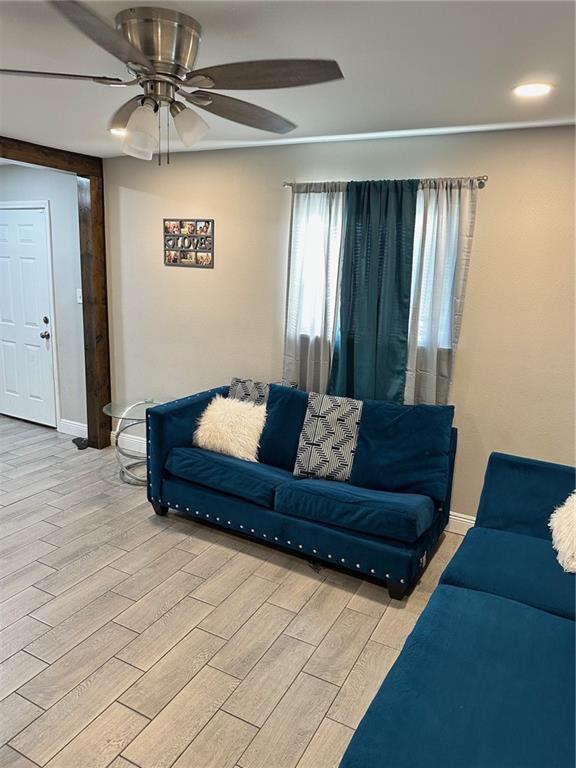 living room with ceiling fan and light wood-type flooring