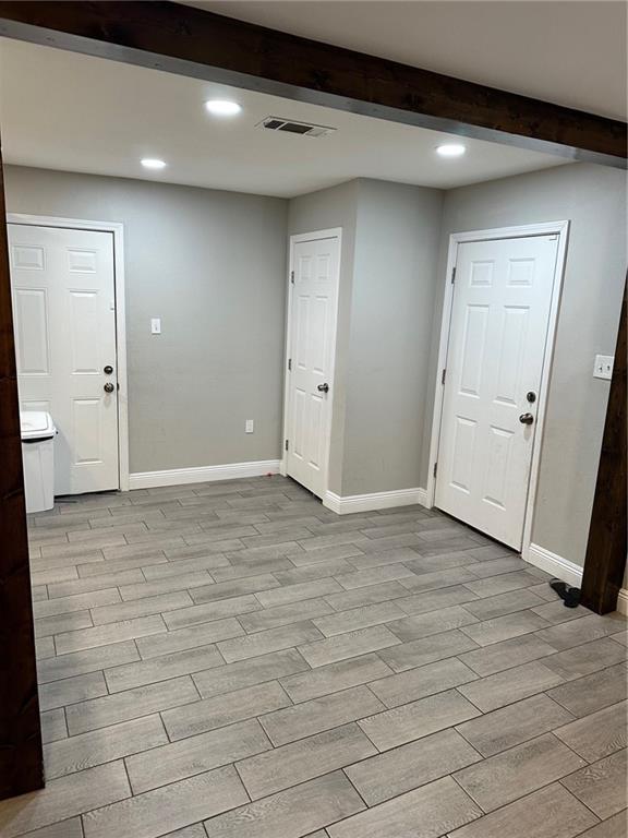 entryway with beamed ceiling and light wood-type flooring