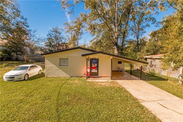 ranch-style house featuring a carport and a front lawn