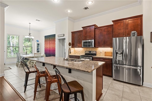 640 Pine Grove Loop, Madisonville, LA 70447 - kitchen featuring stainless steel appliances, backsplash, a breakfast bar area, light stone countertops, and a chandelier