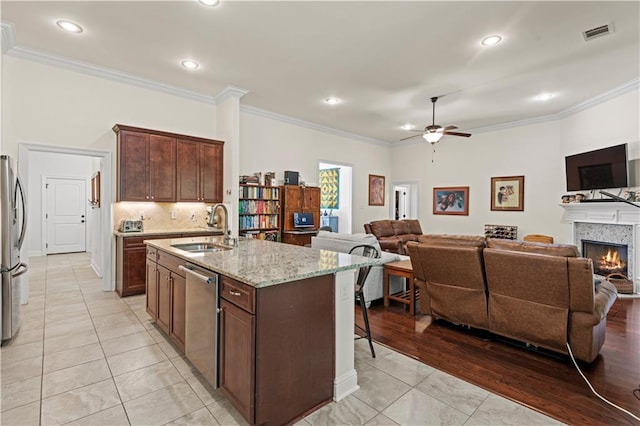 640 Pine Grove Loop, Madisonville, LA 70447 - kitchen with open floor plan, appliances with stainless steel finishes, a ceiling fan, a kitchen breakfast bar, and light stone counters