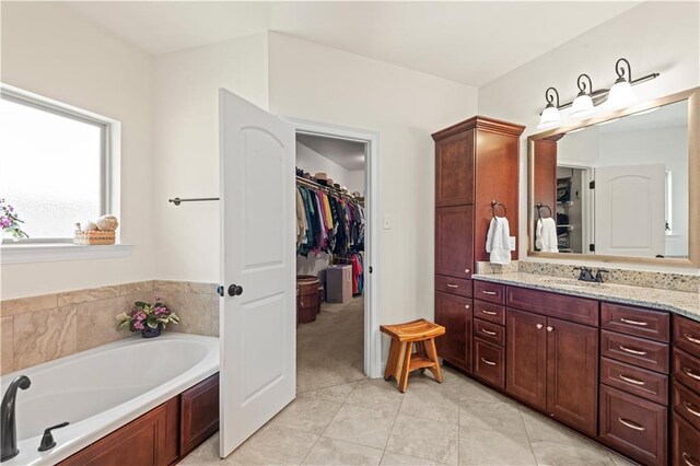 640 Pine Grove Loop, Madisonville, LA 70447 - bathroom with vanity, a garden tub, tile patterned flooring, and a walk in closet