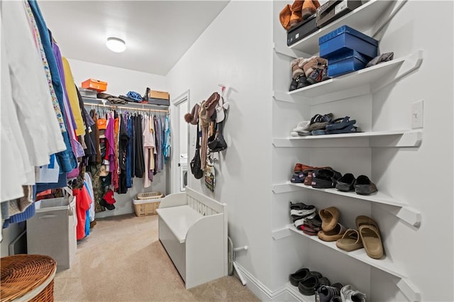 spacious closet featuring light colored carpet