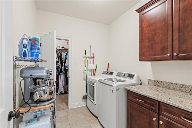 washroom featuring cabinets, light tile patterned floors, and washing machine and clothes dryer