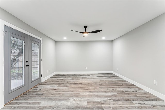 empty room with french doors, light hardwood / wood-style floors, and ceiling fan