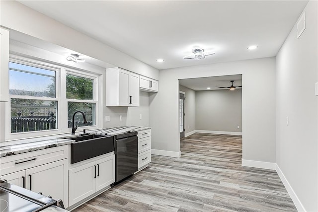 kitchen featuring light stone counters, white cabinets, dishwasher, and light wood-type flooring