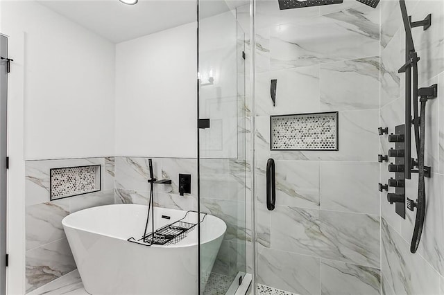 bathroom featuring shower with separate bathtub and tile walls