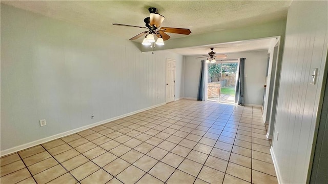 tiled empty room with ceiling fan and a textured ceiling