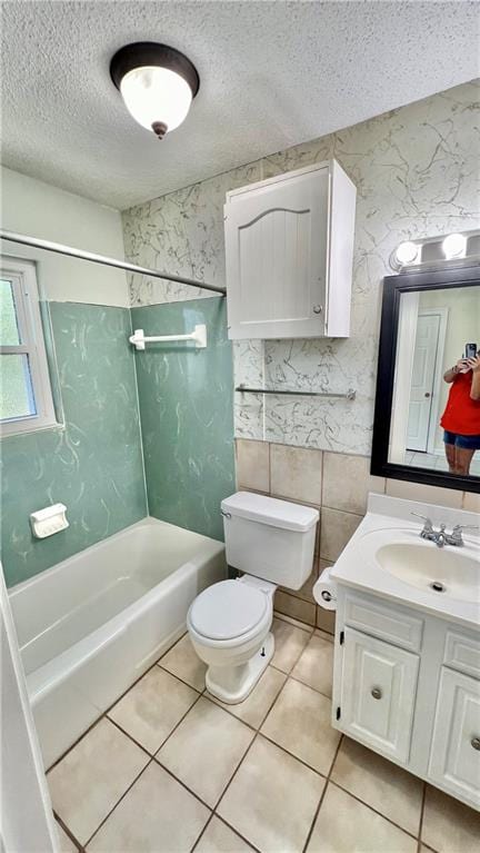 full bathroom featuring vanity, toilet, a textured ceiling, shower / washtub combination, and tile patterned flooring