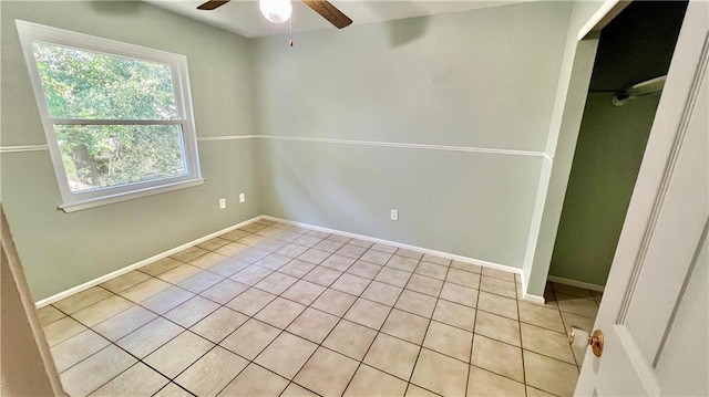 empty room with light tile patterned floors and ceiling fan