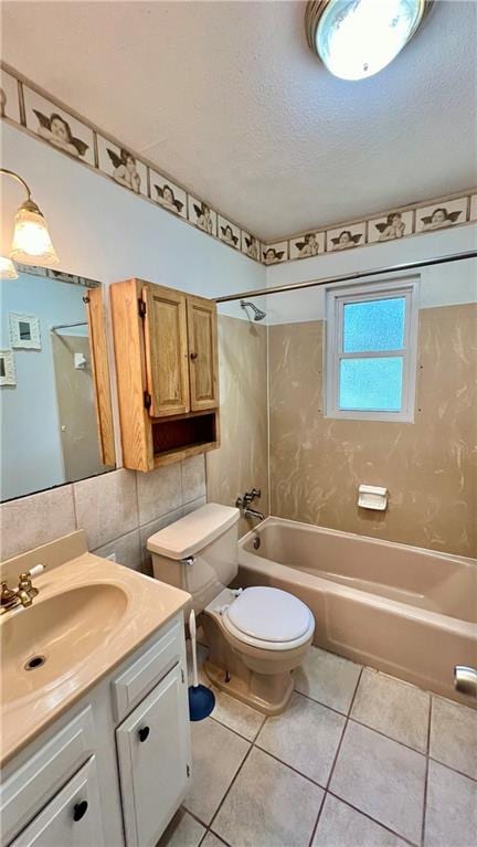 full bathroom featuring vanity, a textured ceiling, tile patterned flooring, toilet, and tiled shower / bath