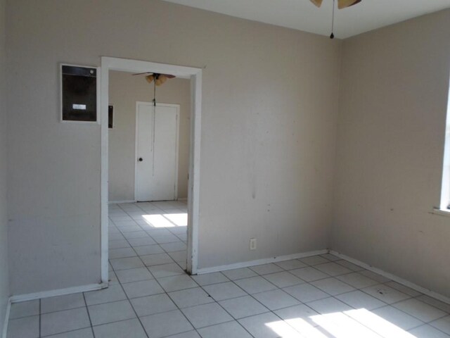 empty room with ceiling fan and light tile patterned flooring