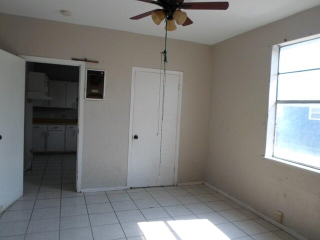 unfurnished bedroom with ceiling fan and light tile patterned floors