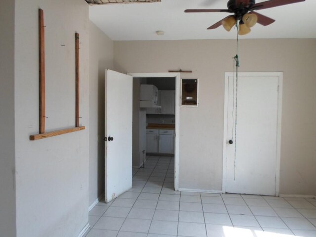 tiled spare room with ceiling fan