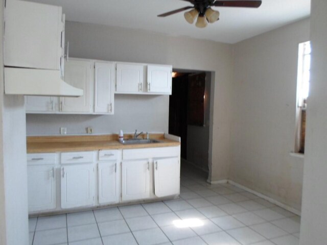 kitchen with white cabinetry, ceiling fan, light tile patterned floors, and sink