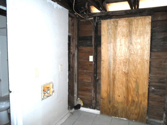 interior space with wood walls and tile patterned floors