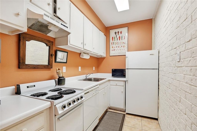 kitchen featuring light tile patterned flooring, sink, white appliances, brick wall, and white cabinetry