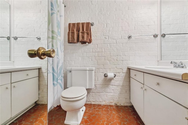 bathroom featuring brick wall, a shower with shower curtain, vanity, and toilet