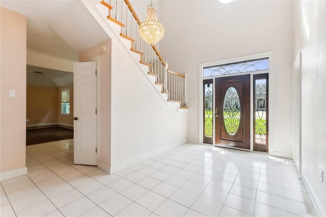 entrance foyer featuring a towering ceiling, a chandelier, and light tile patterned floors