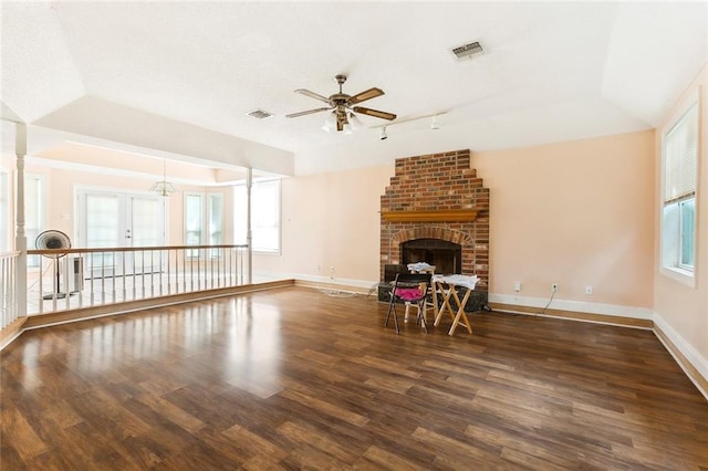 unfurnished living room featuring a brick fireplace, plenty of natural light, and dark hardwood / wood-style floors