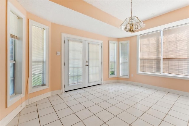 doorway to outside featuring french doors, a notable chandelier, and light tile patterned floors