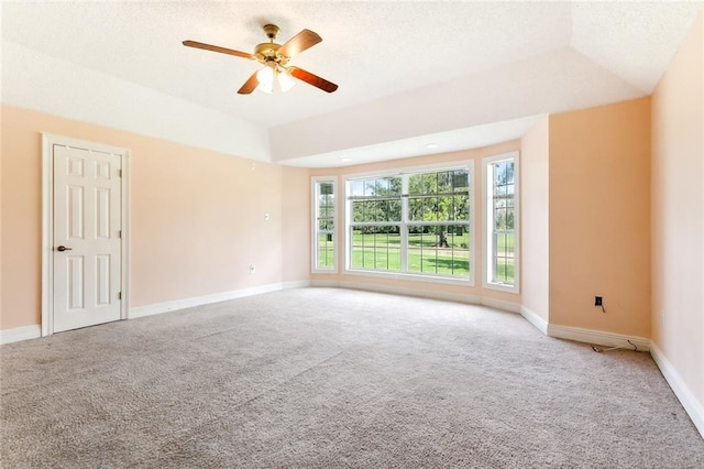 empty room with lofted ceiling, ceiling fan, and carpet floors