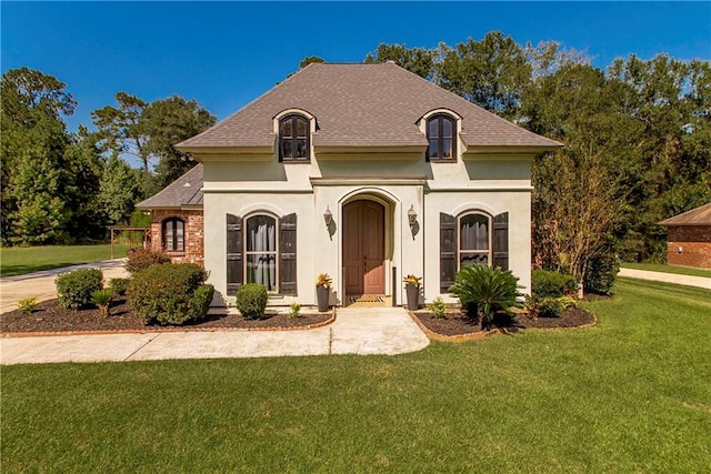 french country style house featuring a front yard