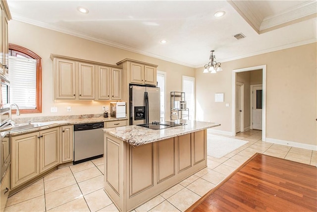 kitchen featuring stainless steel appliances, plenty of natural light, ornamental molding, and a kitchen island