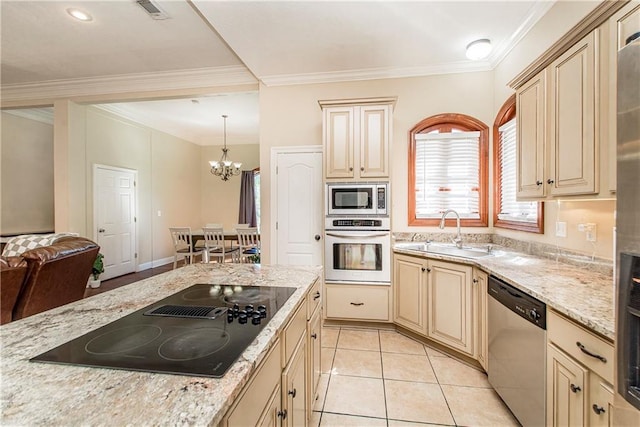 kitchen featuring stainless steel appliances, ornamental molding, decorative light fixtures, and sink