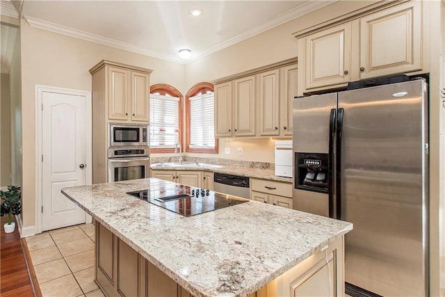 kitchen with light stone counters, ornamental molding, stainless steel appliances, a center island, and light hardwood / wood-style floors