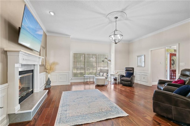 living room with a notable chandelier, a premium fireplace, dark hardwood / wood-style floors, and ornamental molding