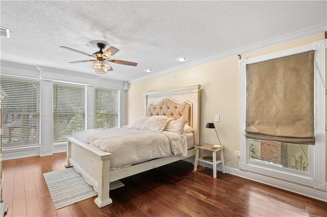 bedroom with crown molding, hardwood / wood-style floors, a textured ceiling, and ceiling fan