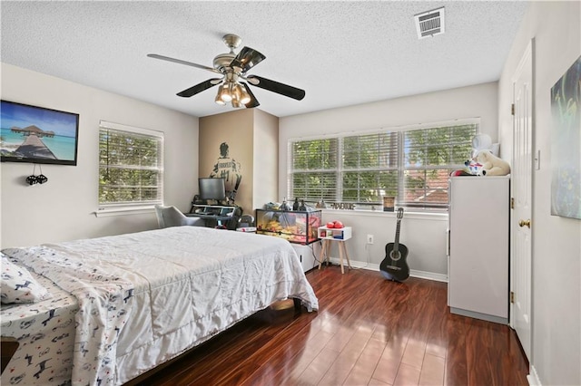 bedroom with dark hardwood / wood-style flooring, a textured ceiling, and ceiling fan