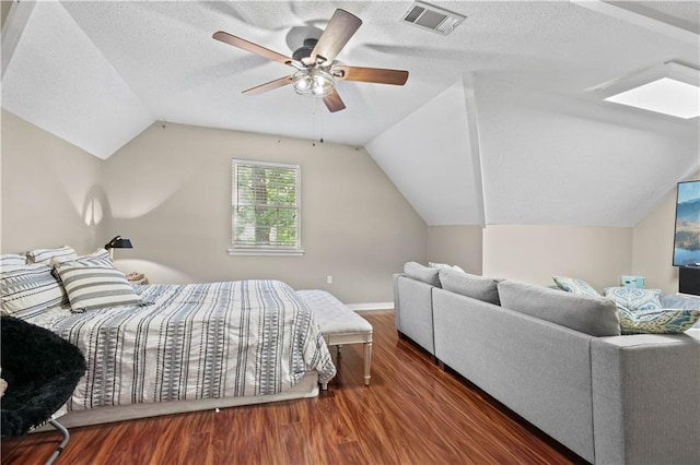 bedroom featuring dark wood-type flooring, lofted ceiling, a textured ceiling, and ceiling fan