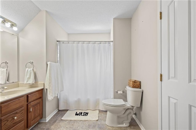 bathroom with vanity, toilet, curtained shower, and a textured ceiling